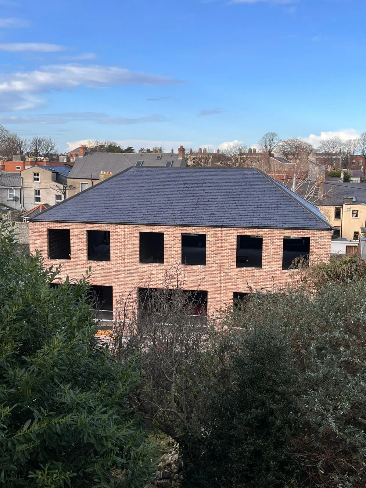 Brick building exterior nearing completion, aerial view